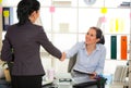 Two women chat to each other in the office. Royalty Free Stock Photo