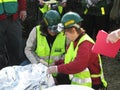 Two women checking injured men on stretcher