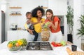 Two women and a child, cooking together in a well-lit, homey kitchen, standing before a modern stove, embodying unity, love and Royalty Free Stock Photo