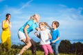 Two women with children playing tag Royalty Free Stock Photo