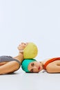 Two women in colorful swimming caps and swimsuits posing together against white background. Vintage beach fashion Royalty Free Stock Photo