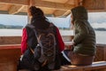 Two women communicate with each other and look at the water. Sitting on the observation tower. Back view