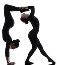 Two women contortionist exercising gymnastic yoga silhouette