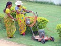 Two women cutting grass