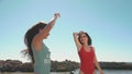 Two women dancing at the beach with hands raised. Greece vibes. Lifestyle, blogger, travel, freedom concept. Filmed