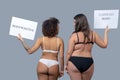 Two women of different physique in underwear standing with their backs. Royalty Free Stock Photo