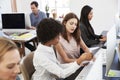 Two women discuss document at a desk in an open plan office Royalty Free Stock Photo