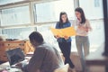 Two women discussing working plan in office. Man working on laptop. Coworking and open space office Royalty Free Stock Photo