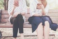 Two women in disinterest moment with smart phones in the outdoor, concept of relationship apathy and using new technology and smar Royalty Free Stock Photo