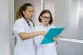 Two women doctor and nurse talking at the hospital on the door background