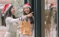 Two women doing window shopping and holding bags in christmas season Royalty Free Stock Photo