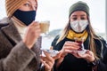 two women drinking turkish tea and salep while wearing medical mask coronavirus time Royalty Free Stock Photo