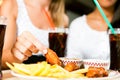 Two women eating chicken wings and drinking soda Royalty Free Stock Photo