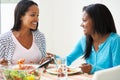 Two Women Eating Meal Together At Home