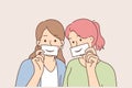 Two women with fake smiles hold papers with drawn emotions and pretend to be happy