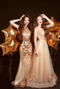 Two women in fashion dress, party celebration. Brunette twins gi Royalty Free Stock Photo