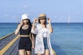 Two women friends or couples relaxing in the sea and walking at tropical beach travel summer holidays. Female tourists enjoy Royalty Free Stock Photo