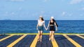 Two women friends or couples relaxing in the sea and walking at tropical beach travel summer holidays. Female tourists enjoy Royalty Free Stock Photo