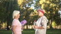 Two women friends meeting before workout in park and giving advices each other