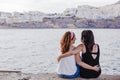 Two women friends sitting by the beach hugging. lifestyle concept outdoors Royalty Free Stock Photo