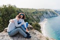 Two women friends sitting, laughing and looking at beautiful sea landscape on top of the mountain. Friendship and nature concept Royalty Free Stock Photo