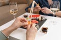 Two women friends sitting by table and eating sushi. Family, friendship and communication concept