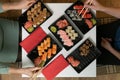 Two women friends sitting by table and eating sushi. Family, friendship and communication concept