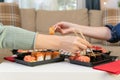 Two women friends sitting by table and eating sushi. Family, friendship and communication concept