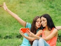 Two women friends taking pictures of themselves with smart phone Royalty Free Stock Photo