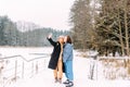 Two women friends in winter with a phone takes a selfie in winter