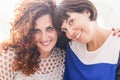 Two women in friendship or relationship hug and stay together with big smile and fun. joy on her faces and beautiful light. short Royalty Free Stock Photo