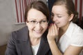 Two women gossip at work