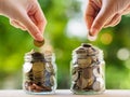 Two women hand putting money coin into glass jar for saving money. saving money and financial concept Royalty Free Stock Photo