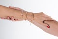 Women hands gripping one another man arm hanging on with jewelry Royalty Free Stock Photo