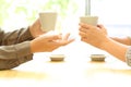 Two women hands talking in a bar holding coffee cups Royalty Free Stock Photo