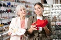 Two women happily discuss choice of modern leather sandals with platform or sneakers Royalty Free Stock Photo