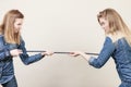 Two women having argue pulling rope