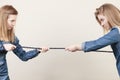 Two women having argue pulling rope