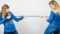 Two women having argue pulling rope