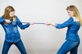 Two women having argue pulling rope