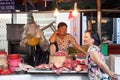 Two women are having a conversation at the wet market