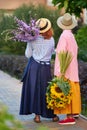 two women holding a bouquet of sunflowers and gladiolus flowers, summer concept Royalty Free Stock Photo