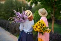 two women holding a bouquet of sunflowers and gladiolus flowers, summer concept Royalty Free Stock Photo