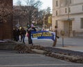 Two women holding up a large banner leading a march