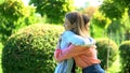 Two women hugging outdoor saying good-bye, friendship trusting relationship