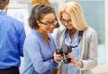 Two women looking at digital camera at office Royalty Free Stock Photo