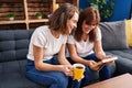 Two women mother and daughter drinking coffee looking photo at home Royalty Free Stock Photo