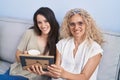 Two women mother and daughter drinking coffee looking picture at home Royalty Free Stock Photo
