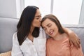 Two women mother and daughter sitting on sofa together at home Royalty Free Stock Photo