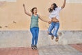 Two women mother and daughter smiling confident jumping at street Royalty Free Stock Photo